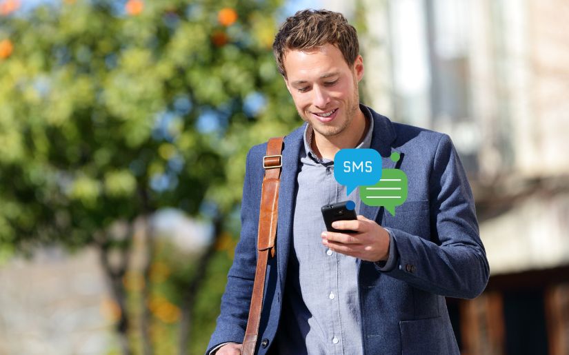 Smart SMS - Young Man reading messages on phone
